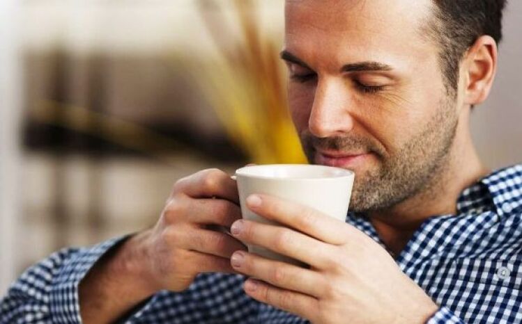 Ένας άνδρας πίνει μια γουλιά τσάι από φυτά για να αυξήσει τη ισχύ