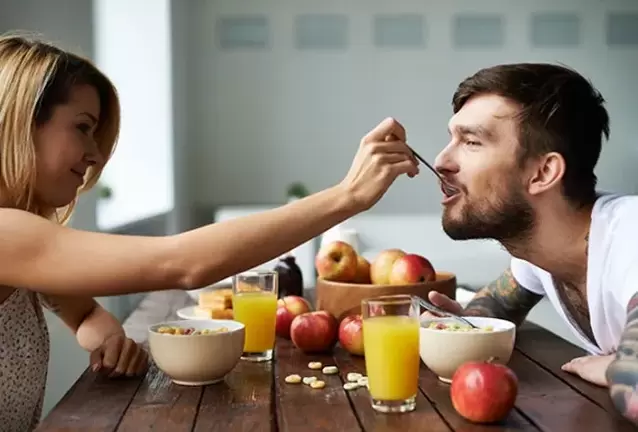 μια γυναίκα ταΐζει έναν άντρα με ξηρούς καρπούς για να αυξήσει τη δραστικότητα